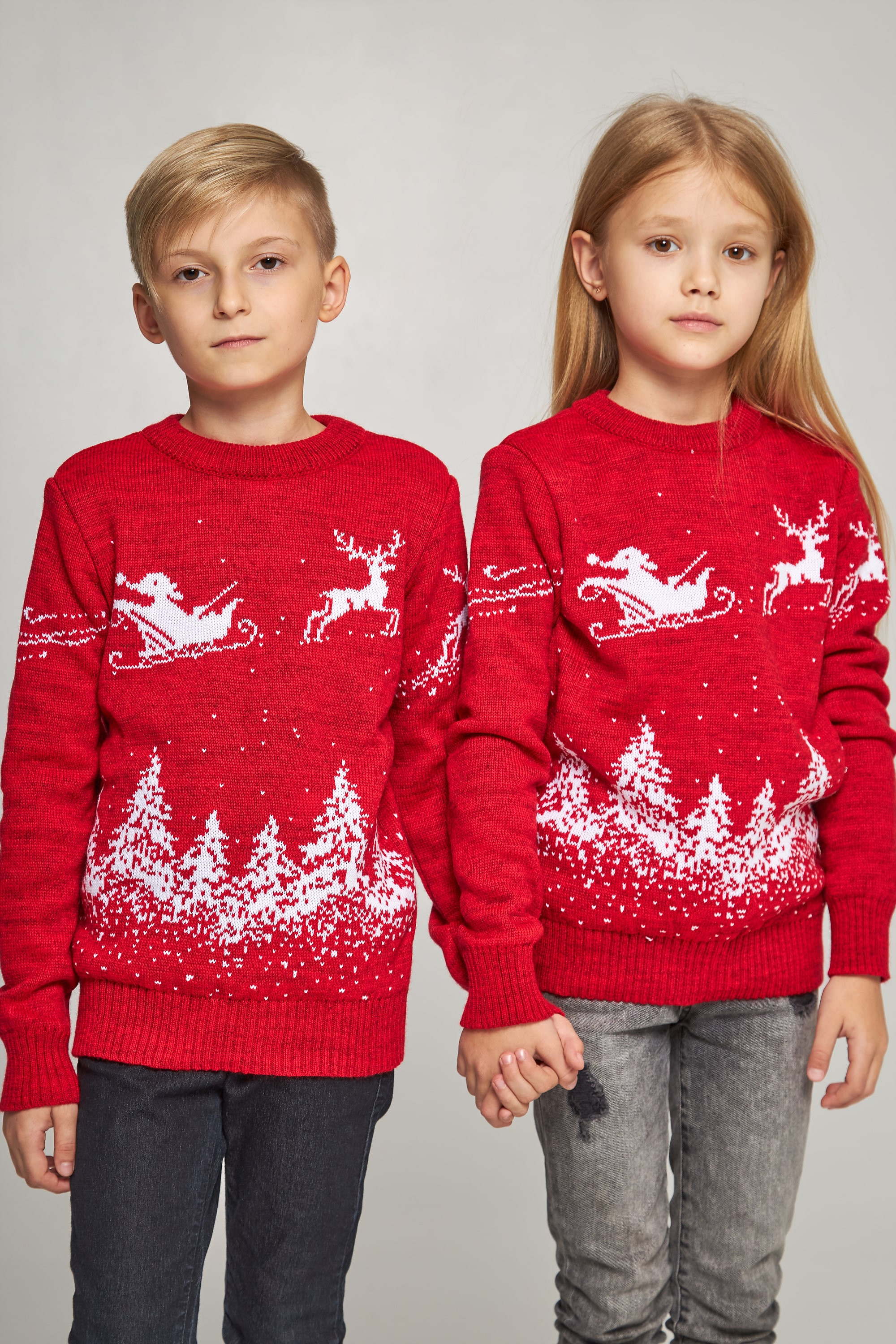 New Year's knitted children's sweaters for two Santa Claus with deer red