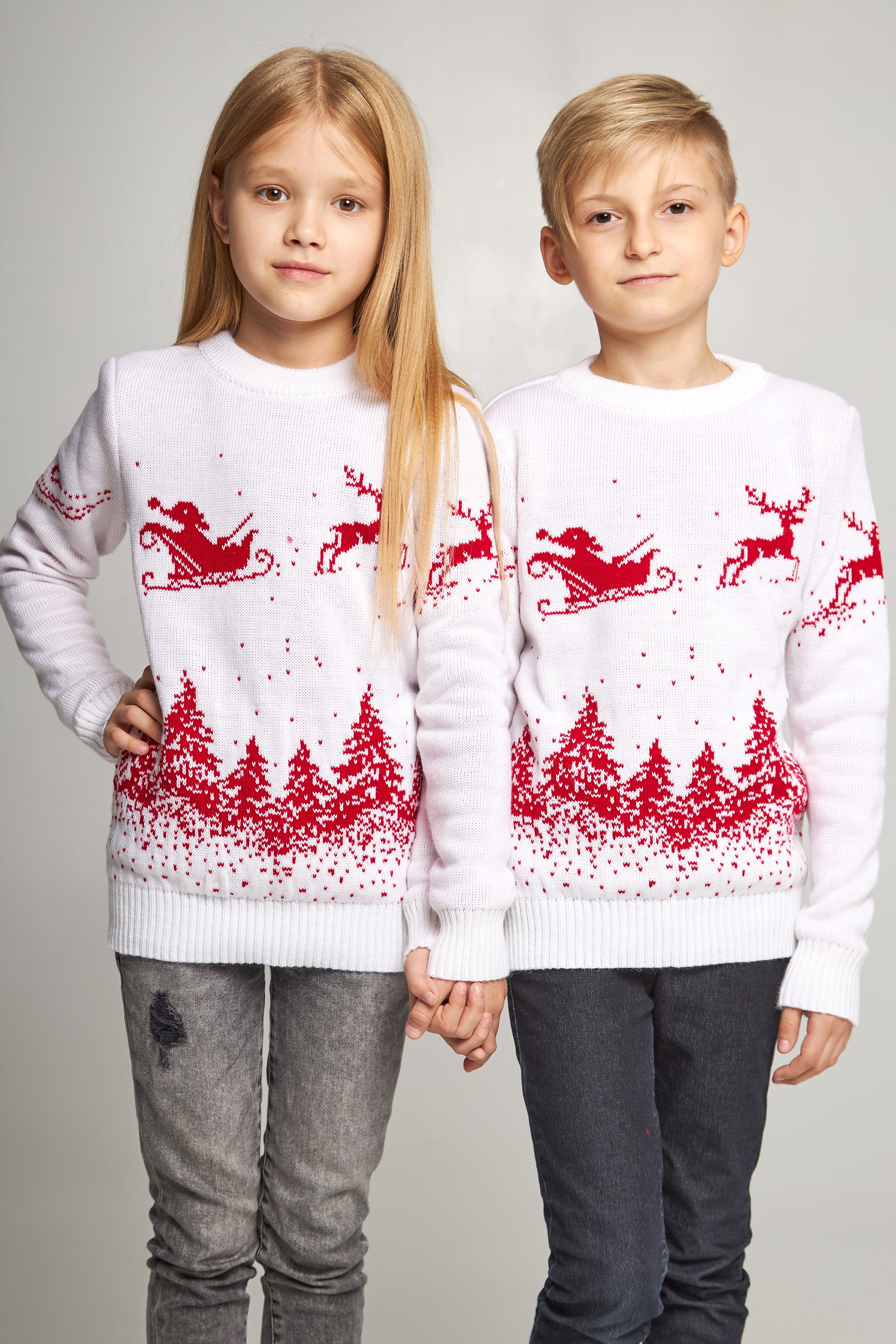 New Year's knitted children's sweaters for two Santa Claus with deer white