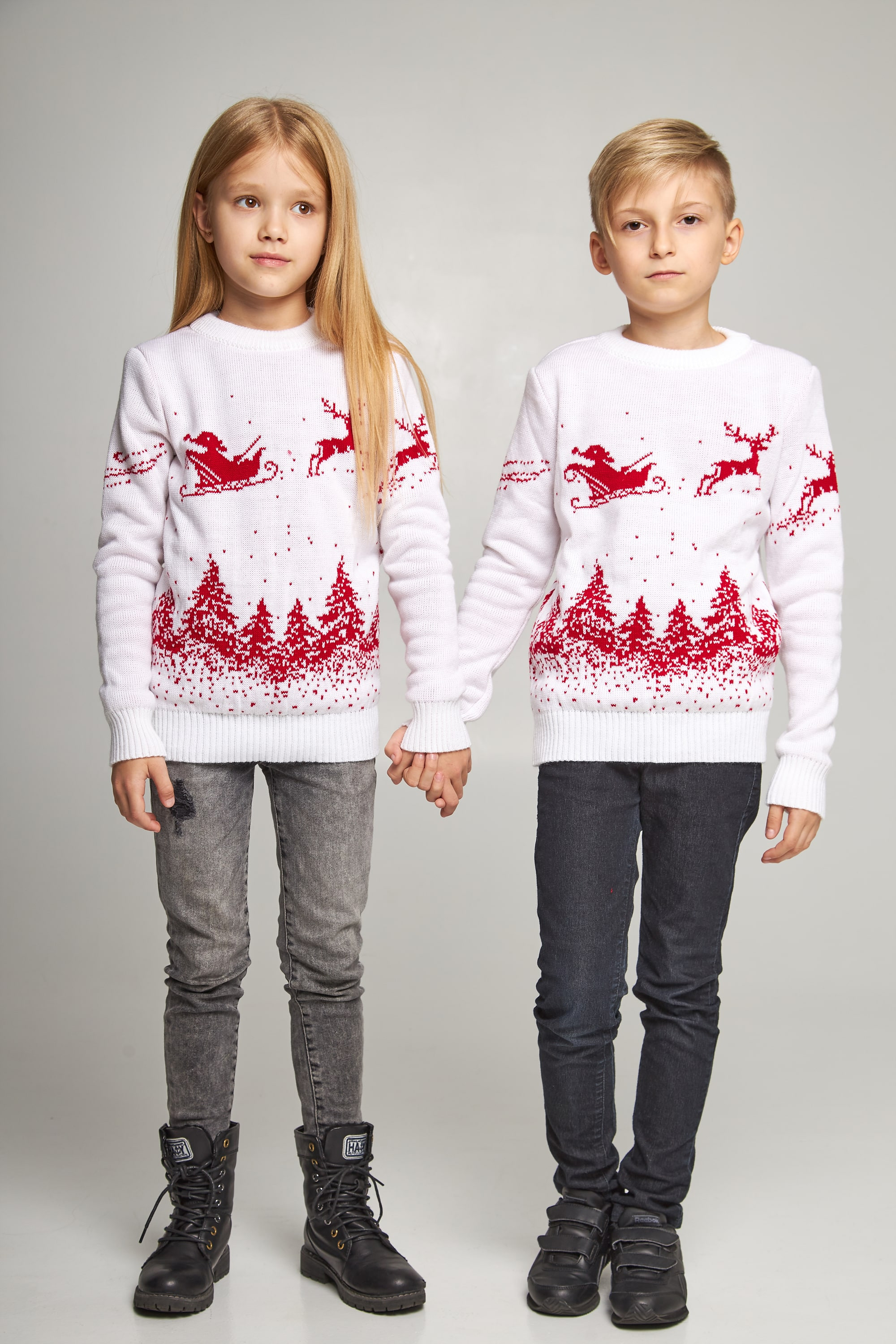 New Year's knitted children's sweaters for two Santa Claus with deer white