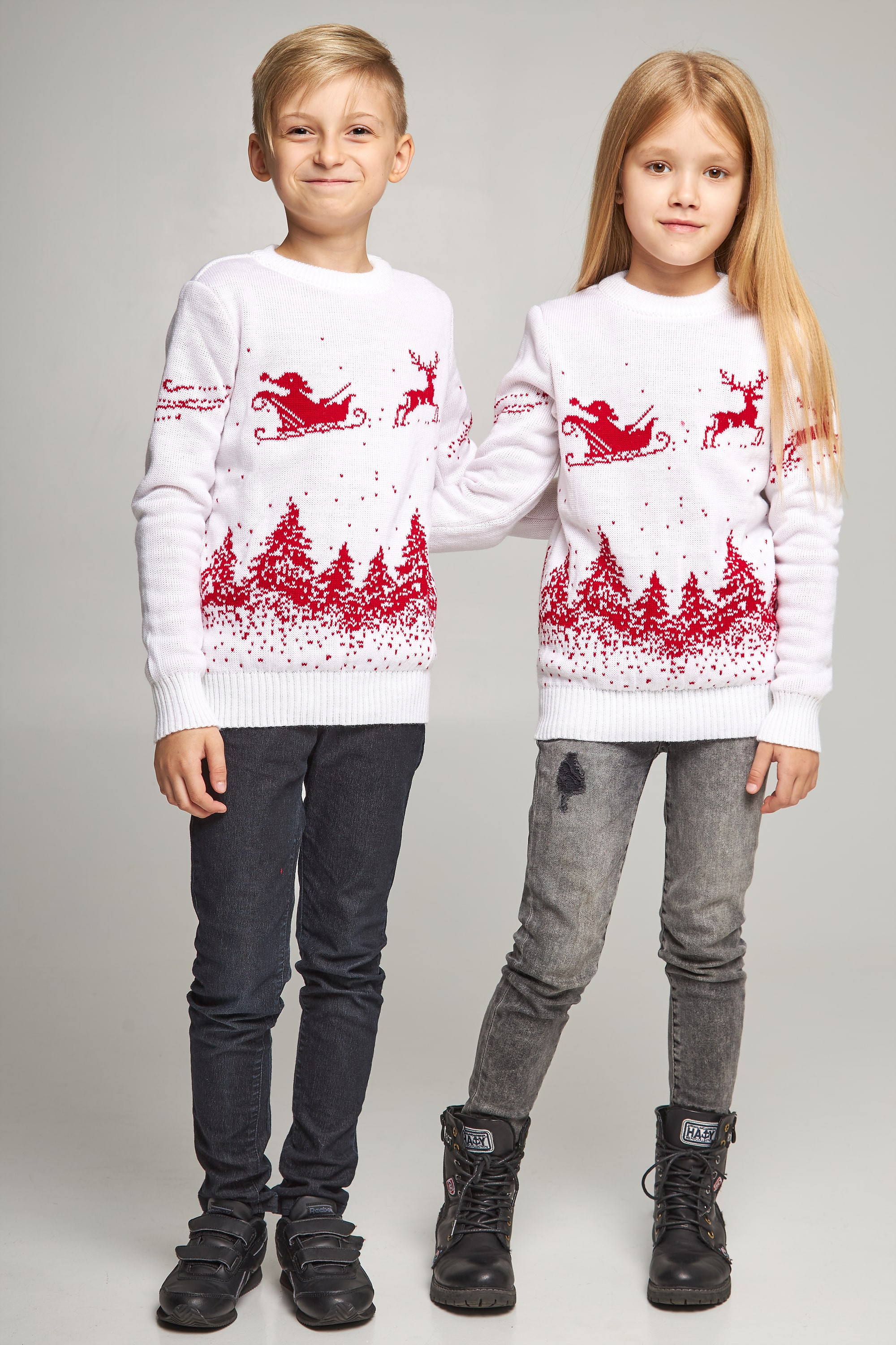 New Year's knitted children's sweaters for two Santa Claus with deer white